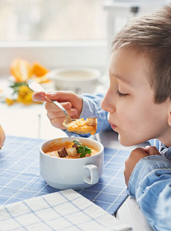 Un niño disfruta de una sopa casera saludable.