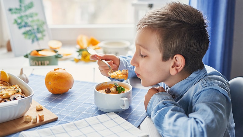 Un niño disfruta de una sopa casera saludable.