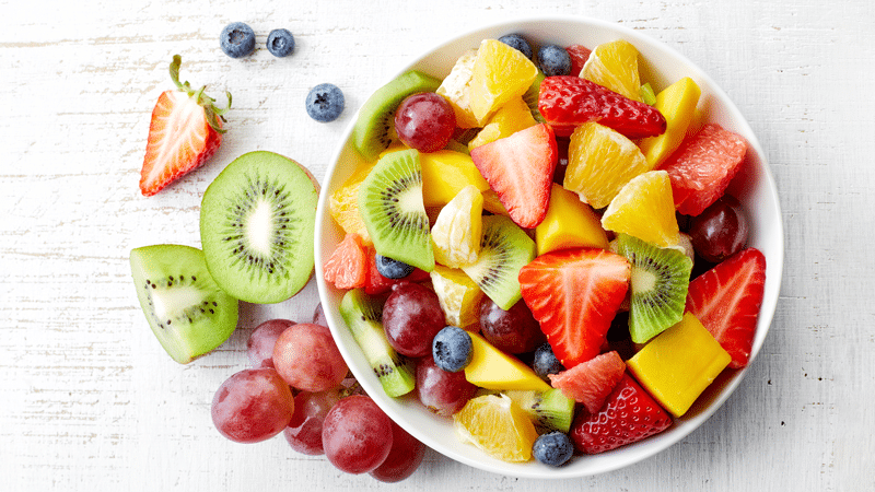 Nutrientes de las frutas y sus beneficios, representados por un platón de frutas variadas.