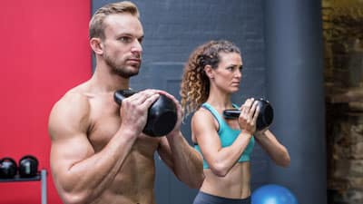 Un hombre y una mujer jóvenes y fuertes hacen ejercicio juntos.